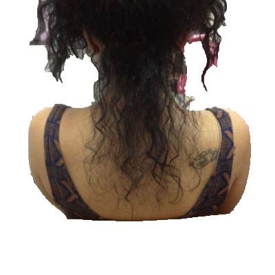 A woman with curly black hair getting hair extensions