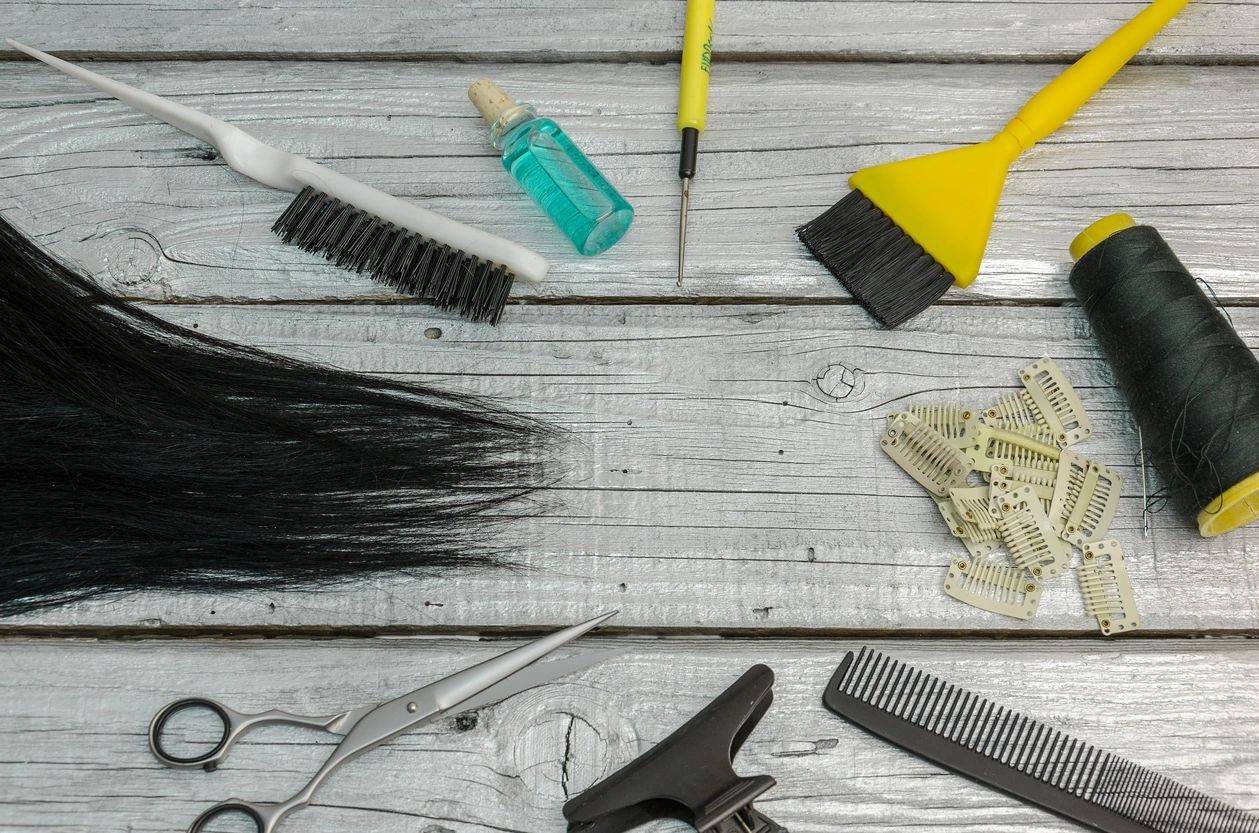 Hair care tools beside black tresses