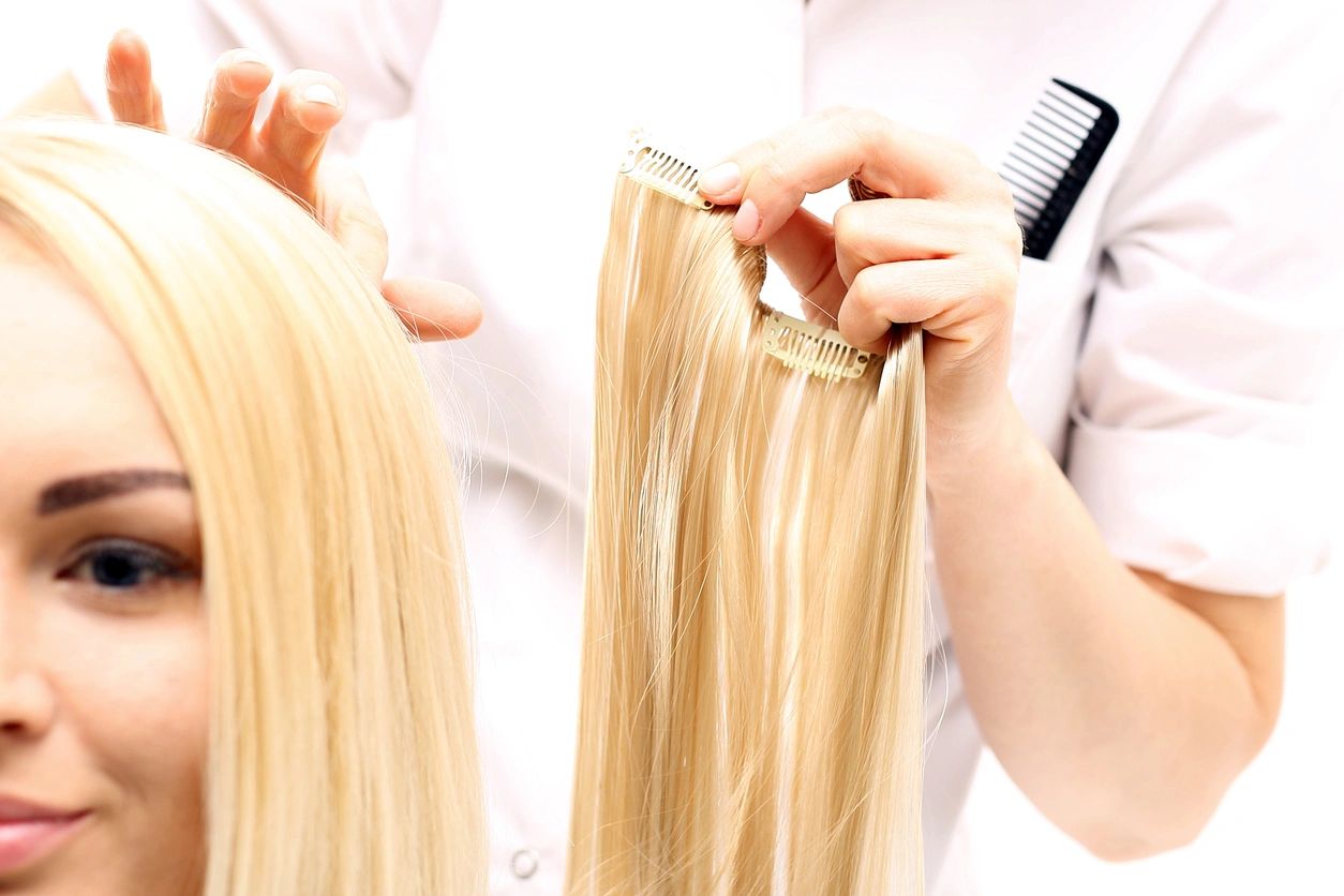 A woman with blonde hair getting extensions
