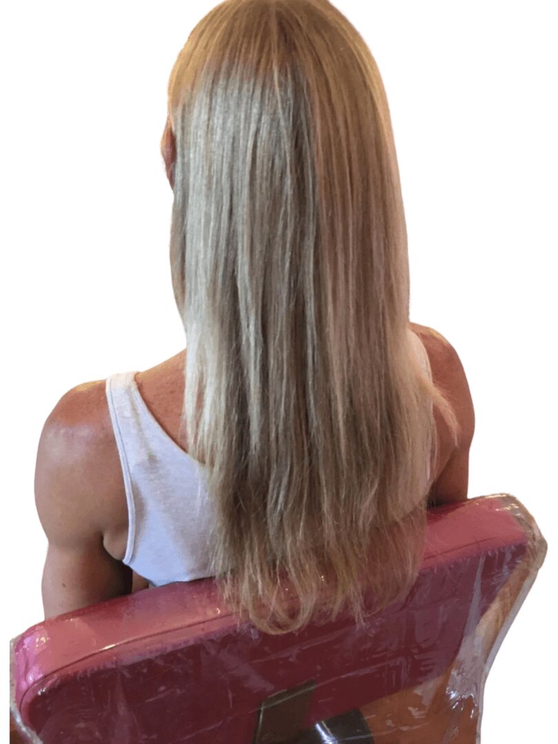 a woman with blond long hair is sitting on a chair